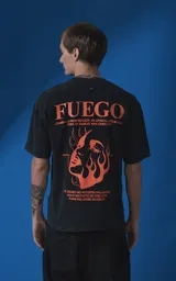 Remera de manga corta con cuello redondo y calce oversize, color negro con efecto nevado. Presenta una estampa frontal en color naranja con diseño gráfico de un rostro rodeado de llamas y texto tipográfico.