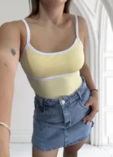 Body amarillo con breteles finos blancos y ribete blanco en escote y cintura.