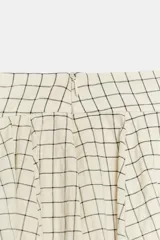 Falda midi de tiro medio color beige con estampado de cuadros finos oscuros. Presenta pliegues en la cintura y bajo abullonado con acabado evasé, de Zara Woman Collection.