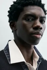 Polo de punto color azul marino, de calce relajado y manga larga. Presenta un cuello solapa de tejido denim en contraste con una abertura frontal en forma de V.