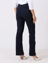 Jean de tiro alto con corte bootcut, ajustado en cadera y muslos con una sutil apertura desde la rodilla. Presenta diseño clásico de cinco bolsillos, cierre con botón y costuras en contraste. Su diseño posterior incluye costuras estratégicas para un efecto de realce en la silueta.