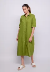 Vestido camisero largo verde oliva de lino y viscosa, con cuello camisero, mangas 3/4 con puños elásticos, cierre frontal abotonado y alforzas verticales en el frente.