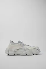Championes Camper modelo Roku, color blanco, estilo slip-on con cordones elásticos cruzados decorativos y suela gruesa texturizada con efecto speckle.