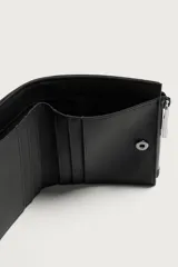 Cartera monedero de acabado engomado en color verde militar, con compartimento principal para billetes, ranuras exteriores para tarjetas y monedero lateral con cierre de cremallera.