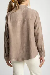 Camisa tipo sobrecamisa de gamuza vegana en color beige, con corte oversize, cuello clásico y cierre frontal con botones a tono.