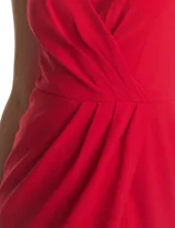 Vestido midi de crepe color rojo, con escote en V cruzado y drapeado en el busto. Presenta una falda envolvente con diseño drapeado que genera una abertura asimétrica en el bajo. Cuenta con tirantes finos y cierre invisible en la espalda.