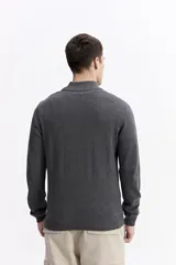 Buzo de punto con medio cierre frontal, cuello elevado y puños acanalados. Presenta un pequeño logo bordado en el pecho.