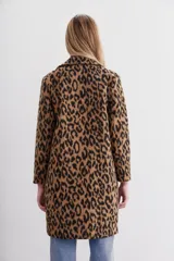 Tapado de corte recto con solapas angostas, cierre frontal con botones y bolsillos ojal. Confeccionado en paño con estampado animal print.