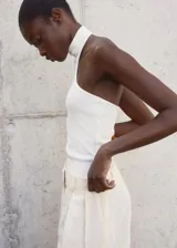 Top de punto fino sin mangas con cuello halter y diseño entallado al cuerpo.