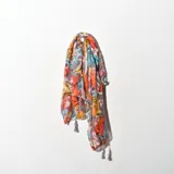 Pashmina estampada con diseño floral en tonos naranja, amarillo, celeste y gris, con flecos en los extremos.
