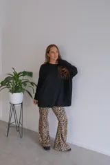 Conjunto de dos piezas compuesto por un buzo de cuello redondo y mangas largas con diseño holgado y un pantalón de corte recto y tiro alto. Ambas prendas están confeccionadas en tejido de punto acanalado.