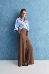 Pantalón wide leg de color negro, con cintura de tiro alto, lazo ajustable y caída fluida.