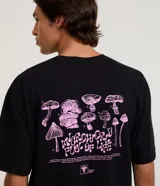 Remera negra de corte relajado, manga corta y cuello redondo, con estampa en la espalda de ilustraciones de hongos en color rosado y texto descriptivo.