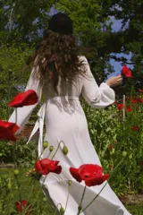 Vestido tipo batón de crepe color blanco, con escote en V, mangas largas abullonadas con puños elásticos y diseño envolvente con lazo de ajuste en la cintura. Presenta un largo irregular con volado en el ruedo.