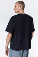 Remera de algodón color negro con cuello redondo acanalado, mangas cortas y hombros caídos. Presenta un estampado frontal en color blanco con la inscripción New York City y un monograma central.