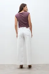 Jean culotte color crudo, de corte ancho y largo hasta el tobillo, con costuras visibles en contraste.
