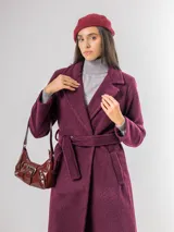 Tapado de paño en color merlot, con diseño de solapas clásicas, cierre frontal con lazo ajustable a la cintura y bolsillos laterales. Presenta una textura suave y una caída estructurada.