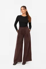 Pantalon de pana marron de corte wide leg, con cintura alta, cierre frontal con boton y pinzas delanteras.