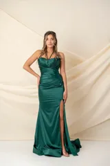 Vestido largo de satén de seda color verde esmeralda, con escote halter, espalda descubierta con tiras cruzadas y tajo alto en la pierna.
