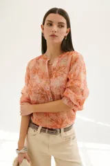 Camisa color coral con estampado floral, cuello mao y mangas 3/4 con volados.