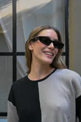 Lentes de sol con armazón rectangular de estilo moderno y minimalista, en color negro con cristales oscuros.