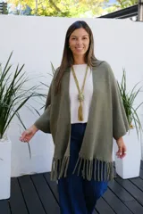 Saco abierto de tejido de punto en color verde oliva, con mangas tres cuartos y detalle de flecos en el ruedo.