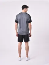 Remera deportiva gris oscuro con mangas cortas negras y logo pequeño estampado en el pecho.