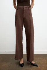 Jeans de tiro alto, pierna ancha y largo al tobillo, en denim celeste claro con efecto lavado. Presenta costura marcada en el centro de cada pierna y cierre frontal con cremallera y botón.