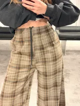 Pantalón tipo balloon de tejido plano con calce relajado, cintura elastizada y estampado cuadrillé en tonos marrones y beige.