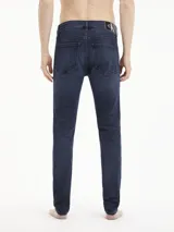 Jeans skinny de denim azul oscuro, tiro bajo, con cinco bolsillos y cierre de cremallera. Confeccionado con algodón reciclado y elastano.