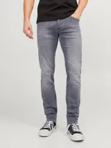 Jean de corte ajustado y tiro bajo, confeccionado en denim gris con acabado lavado. Cuenta con diseño clásico de cinco bolsillos y cierre frontal con botón.