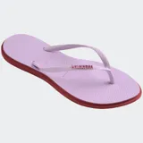 Ojotas Havaianas modelo Slim Point, con suela y tiras más finas, punta ligeramente puntiaguda y borde contrastante. Las tiras son de color lila claro con el logotipo de Havaianas en metalizado. La suela es lila claro con borde exterior en color terracota/rosado oscuro.