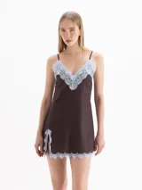 Vestido corto blanco de tirantes finos, con escote en V y detalles de encaje en el escote y el ruedo, con tajo lateral.