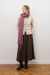 Falda midi de corte acampanado en color marrón oscuro, con costuras verticales decorativas en contraste y cintura elástica.