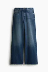 Jean wide leg de tiro alto en denim de algodón con ligero stretch, cinco bolsillos, lavado azul con efecto deslavado y terminación desmechada en el bajo.