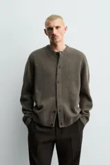 Cárdigan de punto tejido en lana, color marrón oscuro/verde oliva, de calce relajado (regular fit). Presenta cuello redondo, manga larga y cierre frontal de botonadura con botones oscuros.