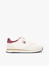 Zapatillas runner Tommy Jeans Eva de estilo urbano, confeccionadas en una combinación de cuero blanco, textil y material sintético. Presentan detalles en color bordó en el talón y el interior, entresuela con franja marrón y suela dentada azul. Cuentan con el logo de Tommy Jeans bordado en el lateral.