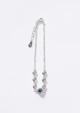 Pulsera de plata 925 con cadena de eslabones, decorada con zirconias circulares y un dije central en forma de corazón con zirconia azul rodeada de pequeñas zirconias blancas. Incluye cadena de alargue con chapita grabada.