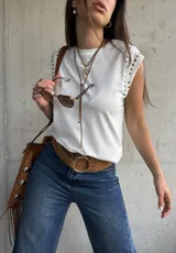 Remera sin mangas de algodón blanco, con cuello redondo y detalle de tachas metálicas en los hombros.