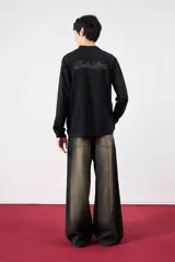 Remera negra de manga larga con cuello alto y logo bordado en el pecho.