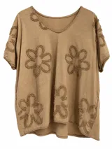 Remera camel de corte holgado, con escote en V y mangas cortas. Presenta apliques bordados en relieve con diseño floral.