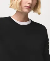 Jersey de punto fino color negro, con cuello redondo y manga larga, de diseño recto.