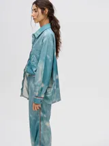 Pantalón de tiro alto con corte recto y holgado, confeccionado en tela liviana con estampado tipo tie-dye en tonos azul y blanco.