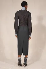 Zapato de tacón destalonado con abalorios y lentejuelas en tonos negros y plateados, escote redondo, punta redonda y tacón fino alto.