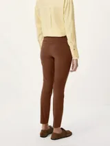 Pantalón sastrero de corte recto y ajuste entallado, con cintura de tiro medio, cierre frontal con botón y bolsillos laterales.