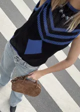 Chaleco calado negro con diseño de rayas diagonales azules.