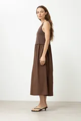 Vestido midi marrón con corte a la cintura, parte superior tipo musculosa y falda amplia.