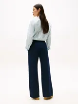 Pantalón de jogging azul marino de pierna ancha, con costura marcada frontal y logo bordado en blanco en el muslo.