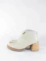 Botas cortas color crema con textura simil cuero de reptil, con cierre lateral y taco de madera.
