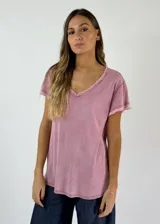 Remera holgada de manga corta y cuello en V con borde deshilachado. Color rosado con efecto desgastado.